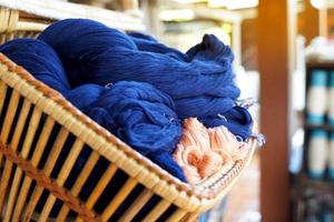 blauw garen gemaakt van katoen en natuurlijk kleuren in een rieten mand. voordat binnengaan de draad kronkelend machine. zacht en selectief focus. foto