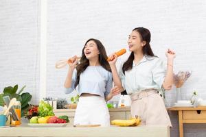 Aziatisch twee Dames vervelend sportkleding eten gezond voedingsmiddelen in keuken. jong mooi meisje gelukkig en genieten aan het eten fruit gezond voedingsmiddelen. foto