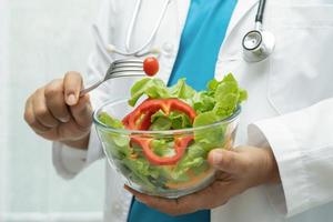 voedingsdeskundige dokter Holding gezond groente vitamine voedsel voor geduldig in ziekenhuis. foto