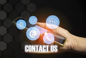 contact ons of onze klant ondersteuning hotline waar mensen aansluiten. en tintje de contact icoon Aan de virtueel scherm foto