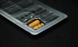 Jakarta, Indonesië - april 21e, 2023 - yunan baiyao capsule tablet Chinese geneeskunde medisch Product fotografie geïsoleerd Aan duidelijk zwart achtergrond foto