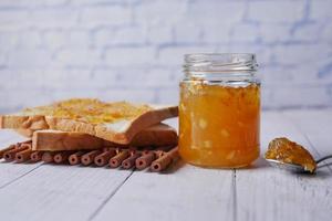 oranje fruit verspreiding Aan een brood Aan tafel foto