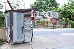 bewakershuis gemaakt van zink bord en hout Bij de Ingang naast lokaal weg in Thailand. foto