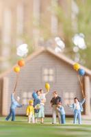 miniatuurmensen, gelukkige familie die in het gazon van de achtertuin spelen. leven thuis concept foto
