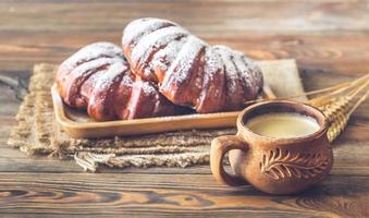 twee broodjes met kop van koffie foto