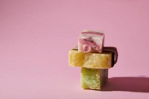 stack van eigengemaakt natuurlijk eco zeep bars met biologisch kruiden ingrediënten voor Gezondheid en spa, geïsoleerd Aan roze achtergrond foto