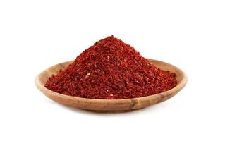 rood Chili peper vlok of grond poeder grof in hout kom geïsoleerd Aan wit achtergrond gochugaru. de stapel van rood Chili peper vlok of grond poeder grof geïsoleerd.rood Chili peper vlok of grond foto