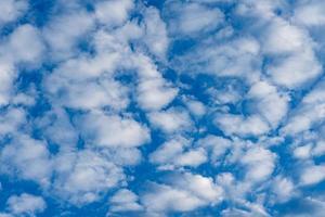 blauwe hemelachtergrond met pluizige witte wolken foto