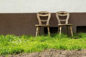 houten stoelen in voorkant van een huis muur foto