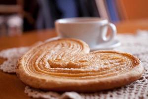 wit kop van zwart koffie en een zoet boterachtig koekje Aan de tafel foto