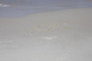 opschrift Aan de zand Aan de zee kust ik liefde u foto