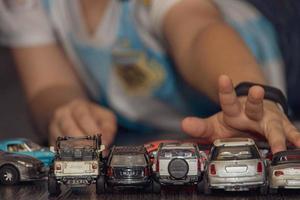 kleurrijk speelgoed- auto's geregeld in een rij Aan de verdieping gedurende een kind Speel foto