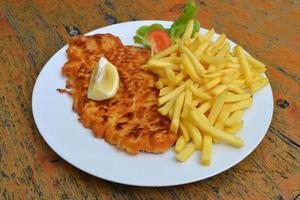 schnitzel met Frans Patat Aan bord foto