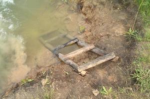 landschap met een vijver en een houten geruïneerd brug foto