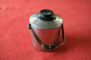 zilver roestvrij theepot met rood achtergrond foto