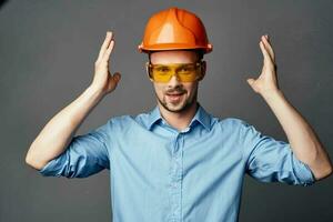 Mens in oranje moeilijk hoed geel bril bouw veiligheid werk foto
