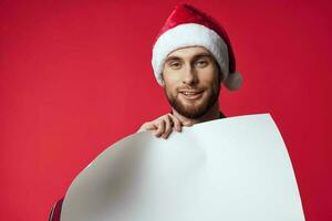 emotioneel Mens in een de kerstman hoed Holding een banier vakantie rood achtergrond foto