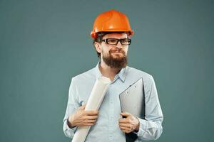 mannetje ingenieur professioneel oranje moeilijk hoed veiligheid bouw blauwdrukken in handen foto