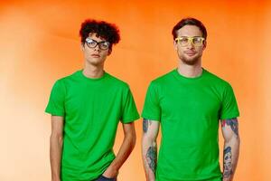 twee vrienden met bril in groen t-shirts zijn staand De volgende naar mode foto