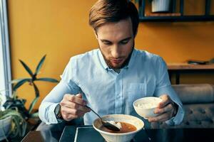 Mens aan het eten borsjt en pilaf cafe restaurant interieur bedrijf financiën overhemd model- foto