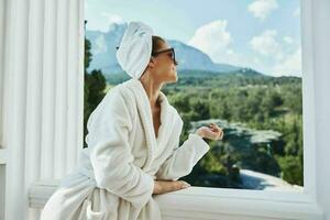 mooi vrouw in een wit gewaad Aan de balkon beetje Aan groen natuur ontspanning concept foto