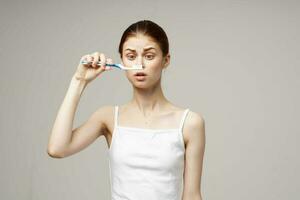 mooi vrouw in wit t-shirt tandheelkundig hygiëne Gezondheid zorg licht achtergrond foto