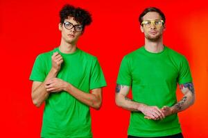 twee vrienden zijn staand kant door kant in groen t-shirts met bril foto