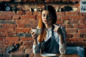 vrouw ober koffie kop zittend Bij de tafel pret werk foto