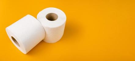 twee rollen wc-papier op een oranje achtergrond