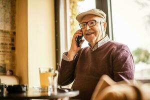 oud Mens Aan de telefoon foto