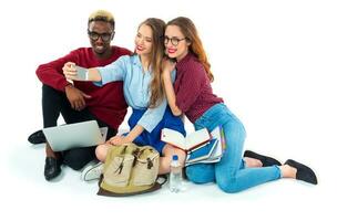 gelukkig studenten met boeken, laptop, Tassen en maakt selfie Aan wit achtergrond foto