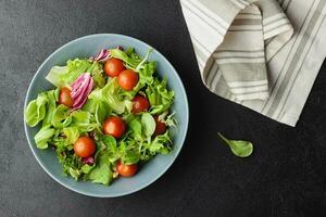 groen salade bladeren in kom Aan zwart tafel. foto