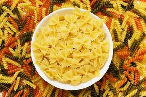rauw pasta Torti en farfalle in wit schaal. foto