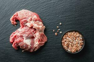 rauw rundvlees vlees Aan een zwart portie bord foto