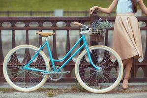 jonge mooie, elegant geklede vrouw met fiets foto