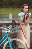 jonge mooie, elegant geklede vrouw met fiets foto