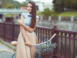 jong mooi, elegant gekleed vrouw met fiets buitenshuis foto