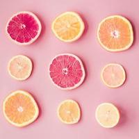 plakjes verse citrusvruchten op roze achtergrond