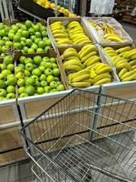 klant kar in groente en fruit afdeling supermarkt foto