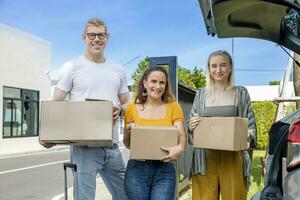 Kaukasisch familie is Holding karton doos naar inpakken binnen de auto romp voor huis in beweging en verhuizing concept. foto