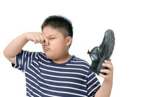 walgde jongen Holding een paar- van stinkend leer schoenen foto