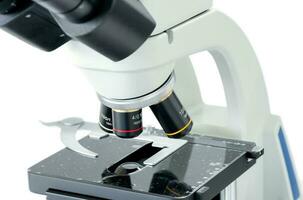 Gesloten omhoog van microscoop geïsoleerd Aan wit achtergrond foto