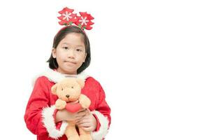 schattig meisje in de kerstman claus pak met teddy beer pop foto