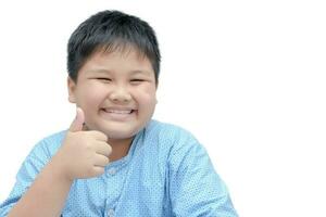 portret van Aziatisch gelukkig dik jongen tonen duimen omhoog gebaar. foto