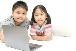 schattig zus en jong broer Speel laptop geïsoleerd foto