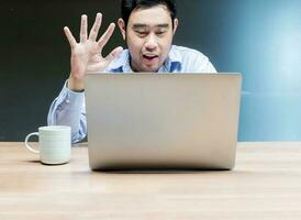 bedrijf Mens op zoek naar Scherm laptop en verhogen hand- groet online vergadering foto