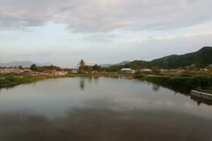 een dorp door de water met bergen in de achtergrond foto