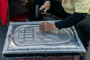 Mens hand- snijwerk metaal gravure Aan straten van Chiang mai foto