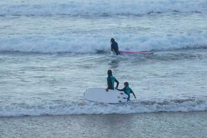 jong atleten beoefenen de water sport van surfing foto