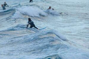 surfers rijden klein oceaan golven foto